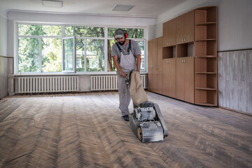 professional worker grinding old parquet