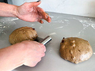 A woman cooks for baking a loaf of rye bread