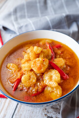 Shrimps curry with red chilli on white wood background