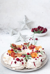 Obraz na płótnie Canvas Meringues pavlova cake wreath with whipped cream, pomegranate and orange