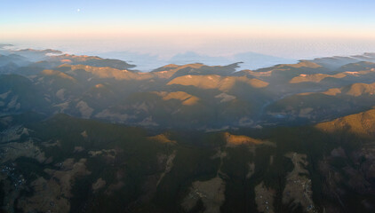 Beautiful mountain panoramic landscape with hazy peaks and foggy valley at sunset