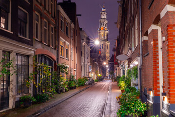 Night street in Amsterdam against the background of the Westerkerk tower.