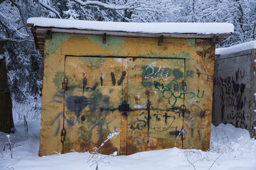 Yellow barn in ugly graffiti covered with snow