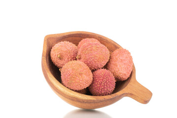 Several ripe organic litchi fruit with wooden utensils, close-up, isolated on white.
