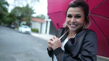 Woman opening umbrella walking outside in city