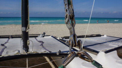 Cuba, February 2012. Sheets are fastened on a yacht on a white sand beach against the backdrop of the turquoise Caribbean Sea