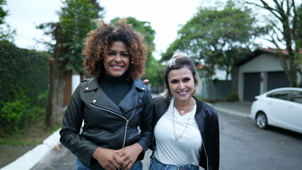 Two women walking together in street. diversity concept, female friends walk outside