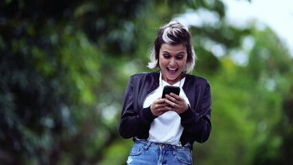 Joyful girl receiving successful message on phone