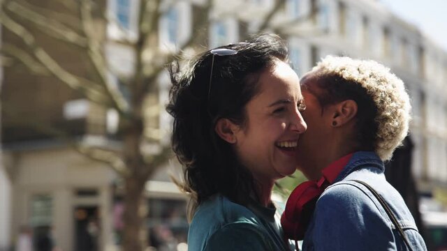 Affectinate lesbian couple kissing and talking in the street