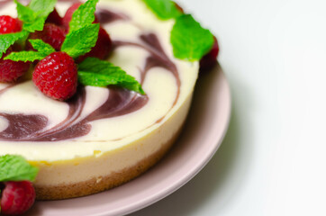 Creamy vanilla baked cheesecake, swirled with raspberry sauce on a biscuit crumb base