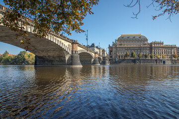 Obraz premium The National Theater in Prague stands on the banks of the Vltava River