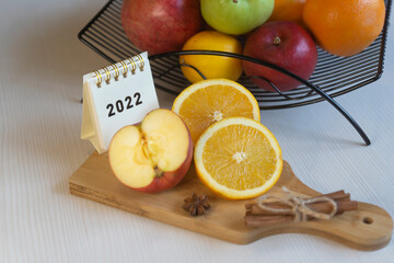 Fruit tea, various fruits in a basket on the table. Calendar 2022, winter mood and spruce branches.