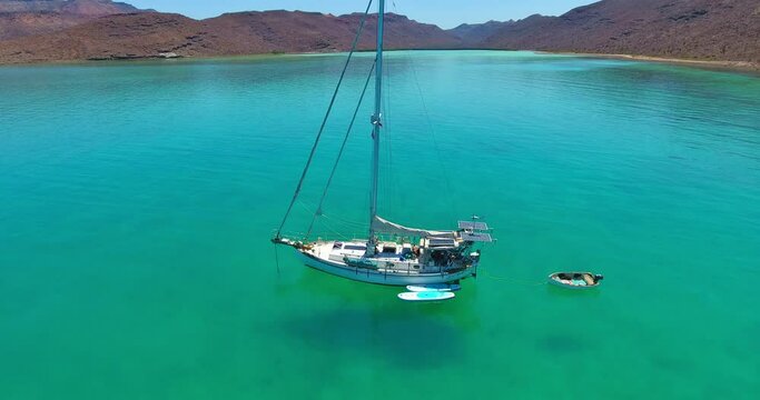 Rising Drone Flight above Anchored Sailboat in Turquoise Lagoon