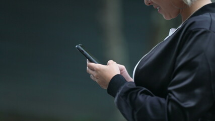 Candid woman looking at cellphone while walking outside