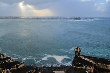 Stormy ocean and cloudy sky with old fortification wall, view from Castillo San Felipe del Morro, Old San Juan, Puerto Rico - obrazy, fototapety, plakaty