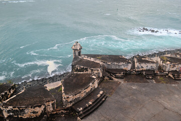 Stormy ocean and cloudy sky with old fortification wall, view from Castillo San Felipe del Morro, Old San Juan Puerto Rico - obrazy, fototapety, plakaty