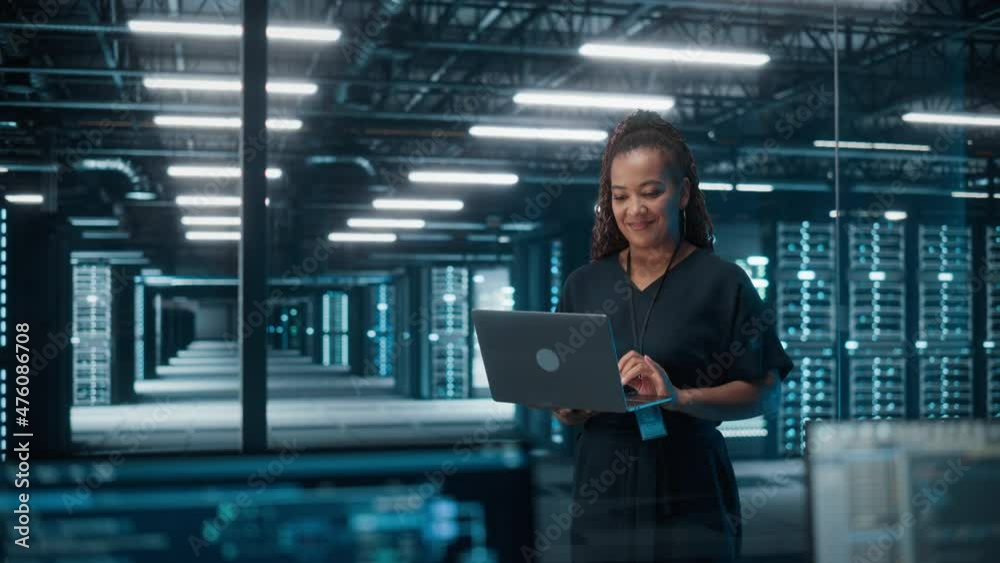 Poster Portrait of African American Female IT Specialist Using Laptop, Standing in Data Center. Infrastructure Architect Works on Web Services. Cloud Computing, Server Analytics, Cyber Security Maintenance