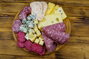Antipasti platter with assortment of italian salami and cheese on wooden table. Top view