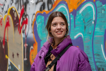 A beautiful smiling girl in font of the colorful city wall. She is laughing. İstanbul,Beyoğlu,Turkey. 11-07-2021.