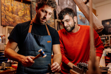 two male brothers working together in their jewelry workshop. men working together arts, crafts and...