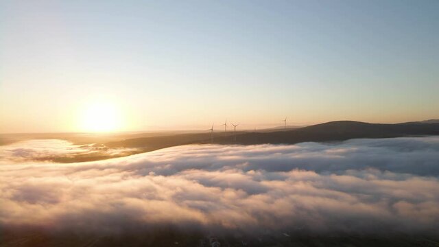 Wind farm in the fog at sunrise. Aerial photography