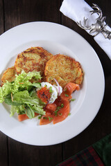 Potato pancakes with red salmon fish. Caviar and poached egg on potato pancakes. The concept of the restaurant menu. Top view with space to copy. He was lying flat. Festive serving. Vertical photo