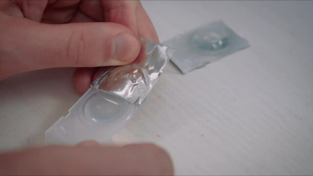 Man take contact lenses from holding plastic container. Vision correction of myopia, hyperopia concept.