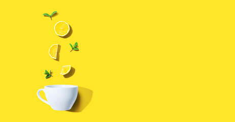 Fresh yellow lemons with tea cup overhead view - flat lay