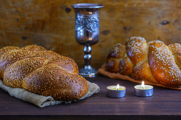 Shabbat Shalom challah bread, shabbat wine and candles on wooden table - obrazy, fototapety, plakaty