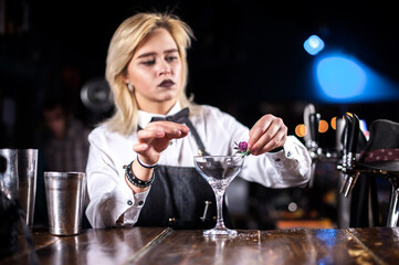 Girl barman creates a cocktail on the taproom