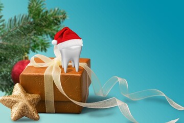 The white tooth in Santa hat on gift podium for the new year. Creative medical stomatology...