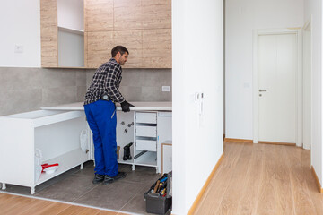 A carpenter sets up a working surface in the kitchen