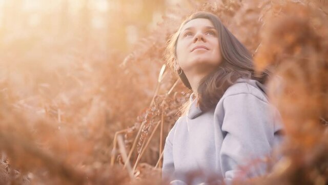 Close up of woman's face at sunset, outdoor relax sunlight, slow motion. Beautiful inspiring woman looking at the sun. High quality 4k footage