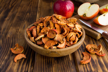 Dried chopped apples in the bowl on the rustic wooden  background. Close-up.