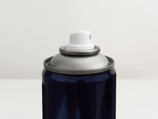 Isolated blue aluminum spray detail. Close up of the top of an aerosol can with spray nozzle....