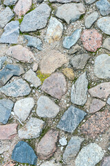 a fragment of a cobblestone pavement of different sizes and shapes. Close-up. Weathered surface