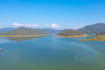 Obraz premium Aerial top view of a dam with forest trees, lake, river, mountain hills in travel and environment concept. Nature landscape background in Thailand.