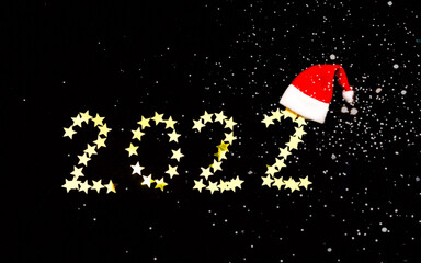 Festive dark background with gold sparkles and digits of 2022 . New Year 2022 concept. Creative copy space.