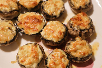 Baked fresh royal champignons filled with sour cream with onions and sprinkled with melted parmesan cheese