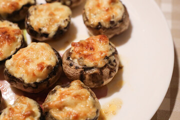 Baked fresh royal champignons filled with sour cream with onions and sprinkled with melted parmesan cheese