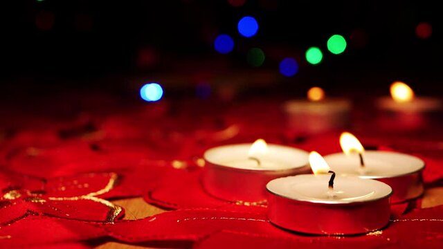 Tealight candles on red background with Christmas lights 
