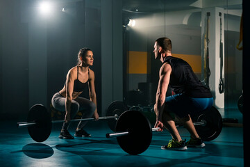 A young woman and man training together in the gym
