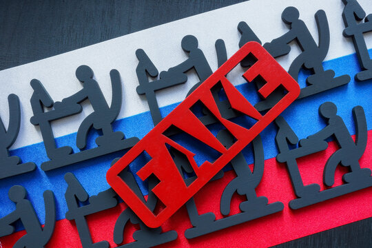 Word Fake, figures with computers on the Russian flag.