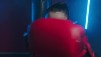 Young energetic woman boxer is training in the fight club. Girl beats with fists in boxing gloves towards the camera. POV-shot through the eyes of an opponent. High quality 4k footage