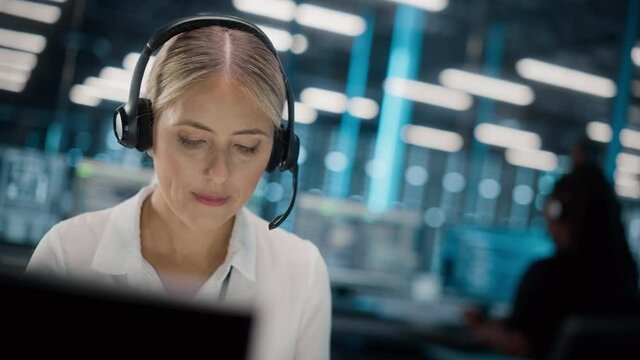 Call Center Office: Portrait of Friendly Caucasian Female Technical Customer Support Specialist Talking on a Headset, uses Computer. Client Experience Officer Helps Online via Video Conference