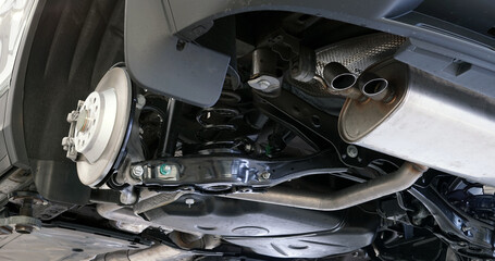 Modern car in a car service on a lift during repairs. The rear wheel is removed from the machine. Selected focus.