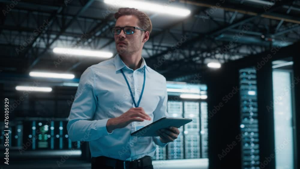 Poster male it specialist using tablet computer in data center, walking through server warehouse. cloud ser