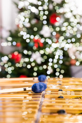 Vibraphone sticks lying on this percussion instrument. In the background, blurry, out-of-focus lights of the Christmas tree.