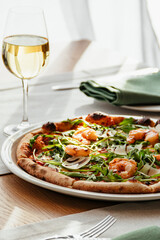 pizza and a glass of wine on the table in the restaurant