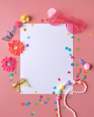 Fototapeta na wymiar White blank paper sheet on the pink background with girly decorative elements and confetti. 